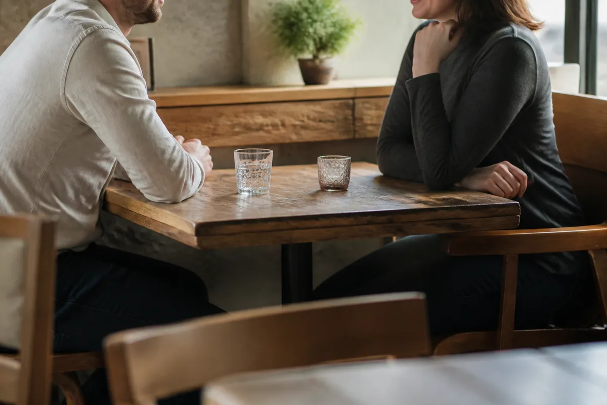 Deux personnes discutant dans un café calme pendant un premier rendez-vous